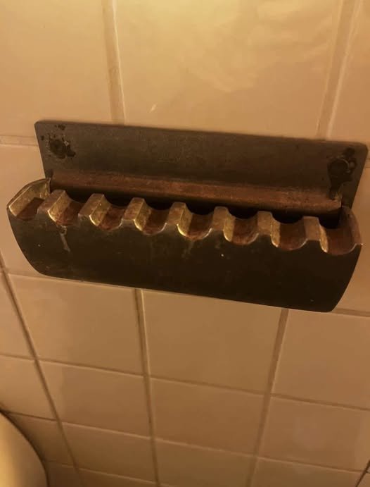 That is a vintage wall-mounted cigarette rest/ashtray (Wandascher).